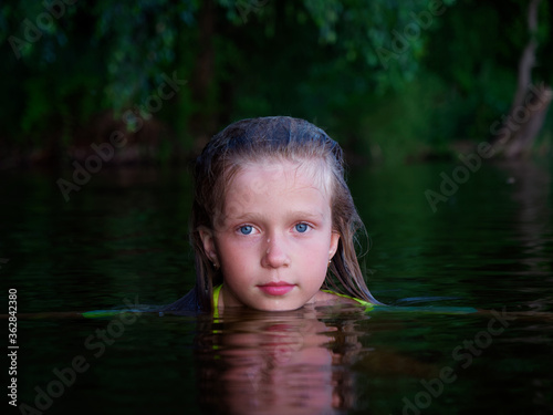 mermaid girls with blue eyes and wet hair in dark water