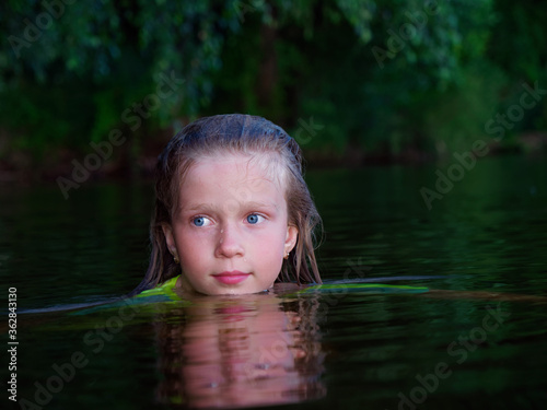 Fototapeta Naklejka Na Ścianę i Meble -  mermaid girls with blue eyes and wet hair in dark water