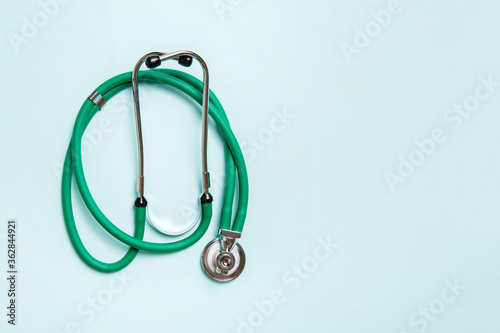 Top view of green medical stethoscope on colorful background with copy space. Medicine equipment concept photo
