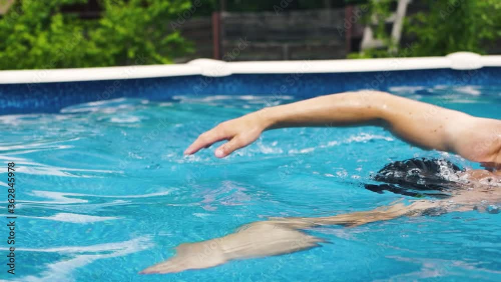 young professional triathlon swimmer athlete practicing at morning home pool. Freestyle swimming training. long footage slow motion young professional triathlon swimmer athlete practicing at morning home pool. Freestyle swimming training. long footage slow motion