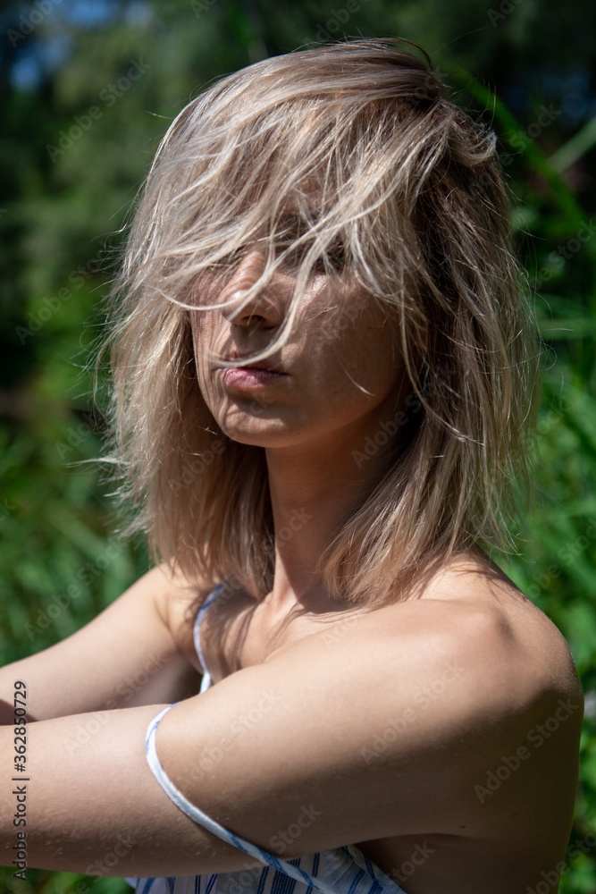 portrait of a girl with light hair in nature. Blonde face hair style. Close his eyes. Sunlight. portrait of a girl with light hair in nature. Blonde face hair style. Close his eyes. Sunlight.