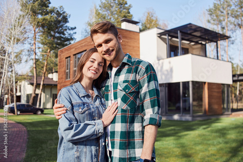 Happy young man hugging his wife outdoors
