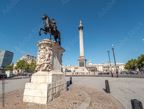 Equestrian Statue of Charles I next to Trafalgar Square on a sunny day. Facade of the building of the National Gallery museum and Nelson's Column in the background. London, United Kingdom.