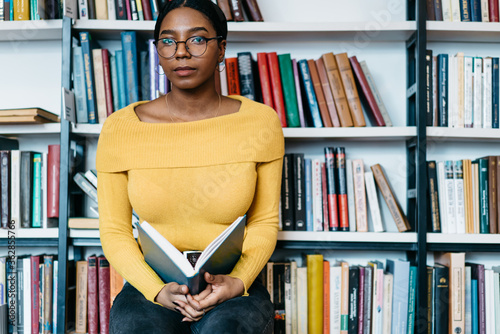 Black female with book near bookcase