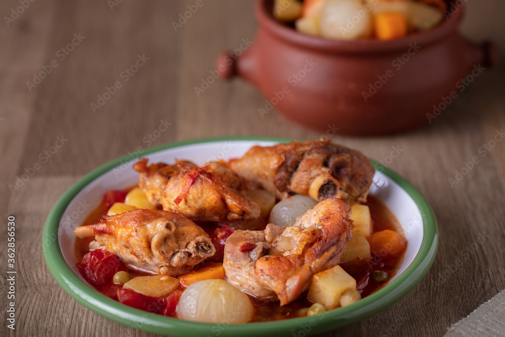 Stewed Chicken with vegetables on wooden table Stewed Chicken with vegetables on wooden table