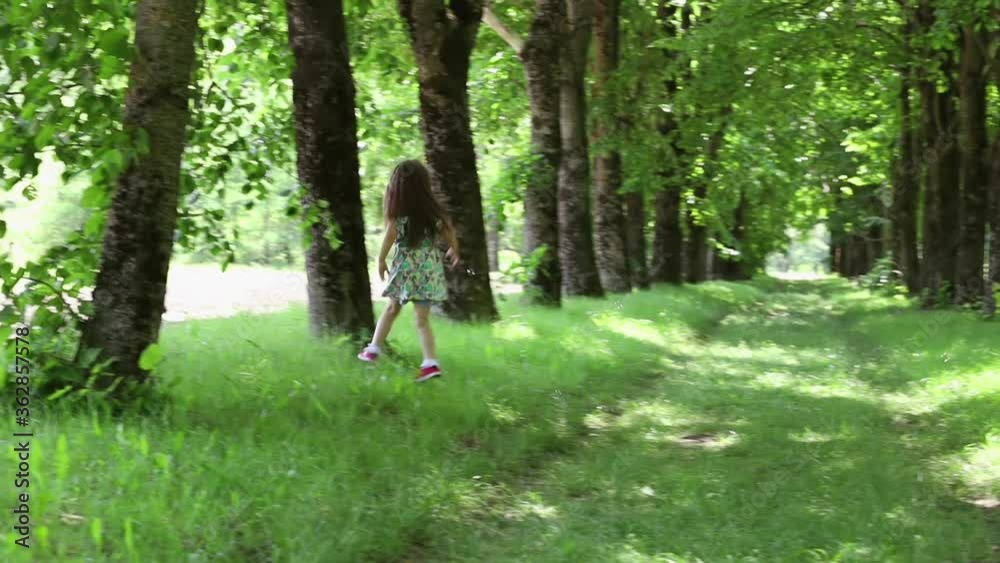 A little girl catches soap bubbles in a forest alley A little girl catches soap bubbles in a forest alley