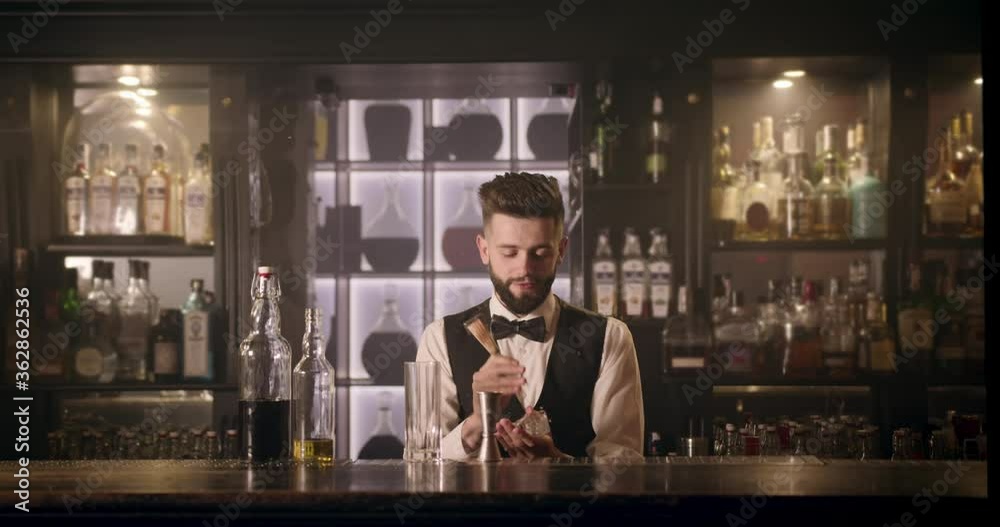 The bartender is crushing an ice cube for a cocktail. 4K