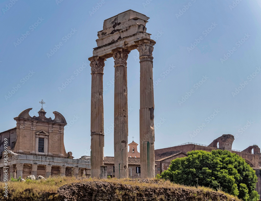 Rome Italy, three columns of the Dioscouroi temple and Santa Franchesca church partial view in the Roman forum