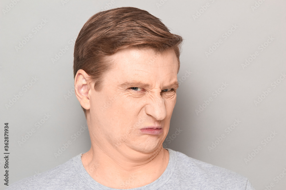 Portrait of funny man grimacing from disgust and squeamishness Portrait of funny man grimacing from disgust and squeamishness