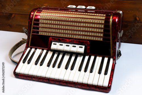 Accordion on a white and wooden background photo