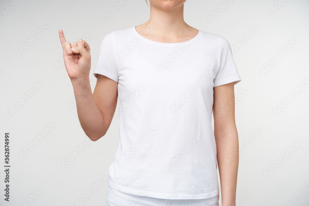 Horizontal shot of young female showing raised little finger while learning deaf alphabet, posing over white background. Human hands and gesturing concept Horizontal shot of young female showing raised little finger while learning deaf alphabet, posing over white background. Human hands and gesturing concept