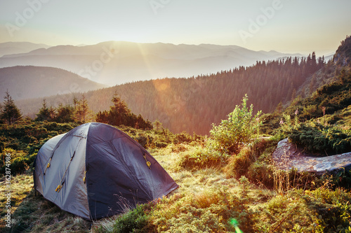 A tent in a field with a mountain in the background