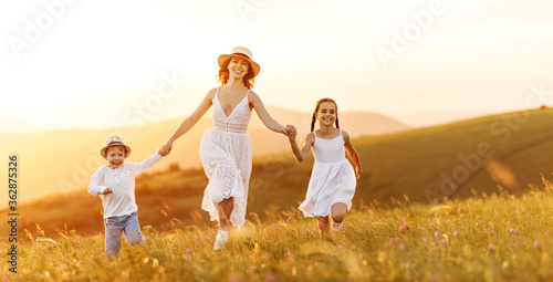 Happy woman with kids running in field.