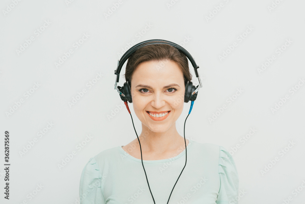 audiometry.Beautiful adult woman during the hearing exam. Testing the patient’s hearing using special headphones in a hearing clinic audiometry.Beautiful adult woman during the hearing exam. Testing the patient’s hearing using special headphones in a hearing clinic