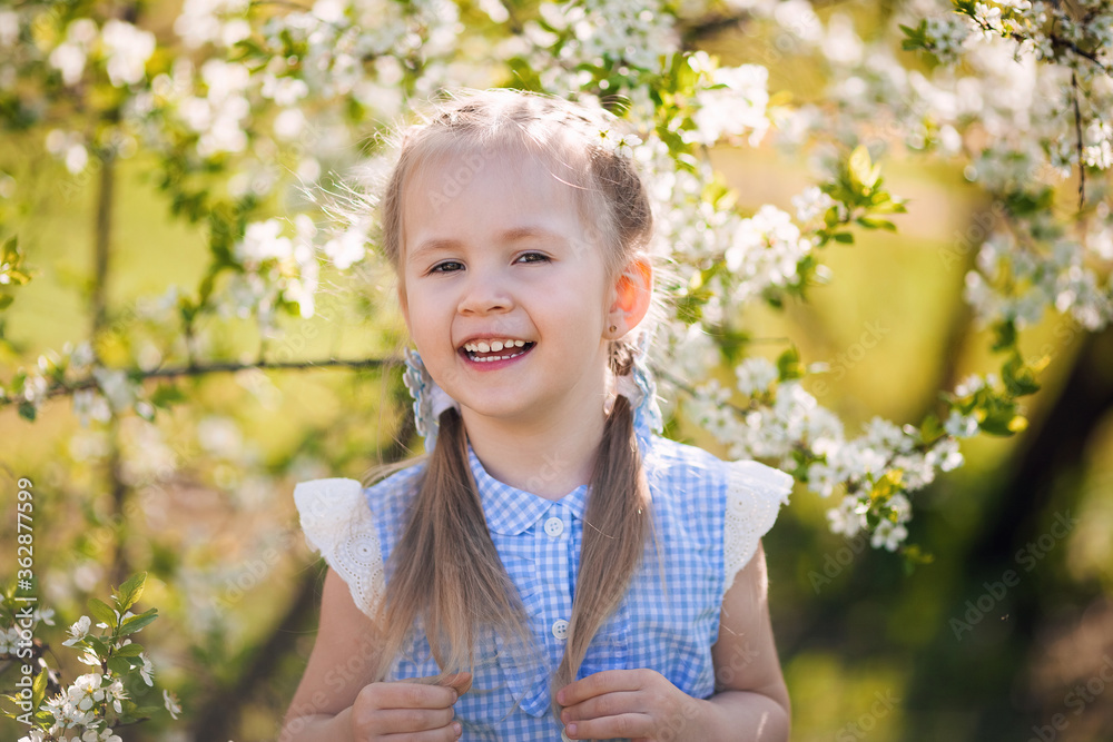 Portrait of beautiful little girl in blooming tree garden on spring day Portrait of beautiful little girl in blooming tree garden on spring day