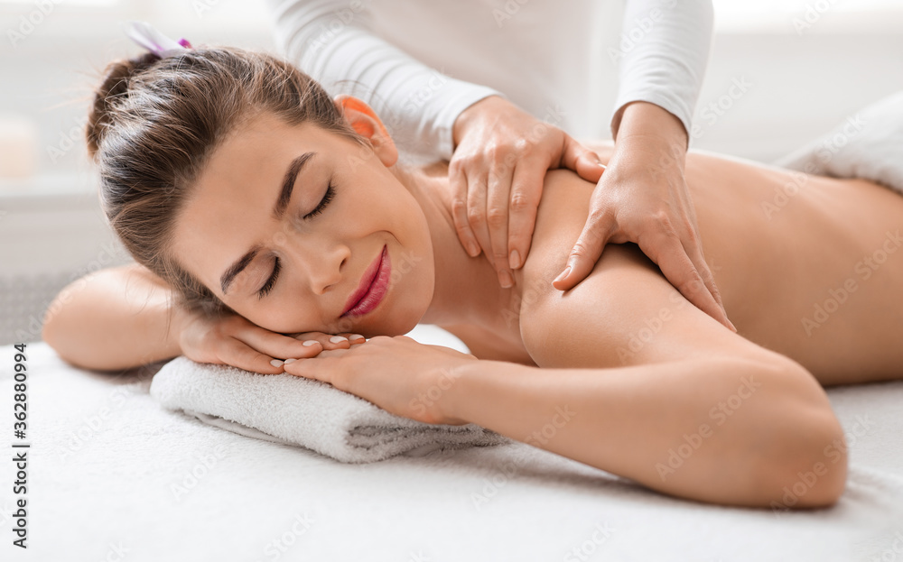 Obraz premium Young woman getting massage session at luxury spa