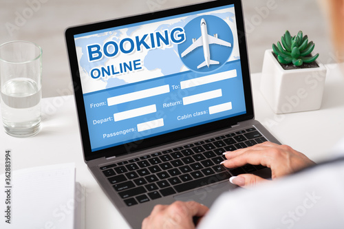 Woman Booking Flight Sitting At Laptop Planning Trip Indoors, Cropped