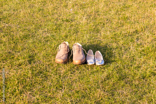Men's and women's or children's shoes and boots on the grass. Concept of outdoor recreation, urban recreation in summer.