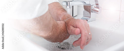 Rinse hands thoroughly with hot water. Protection against coronavirus through frequent hand washing. Horizontal background for a hygiene concept. photo