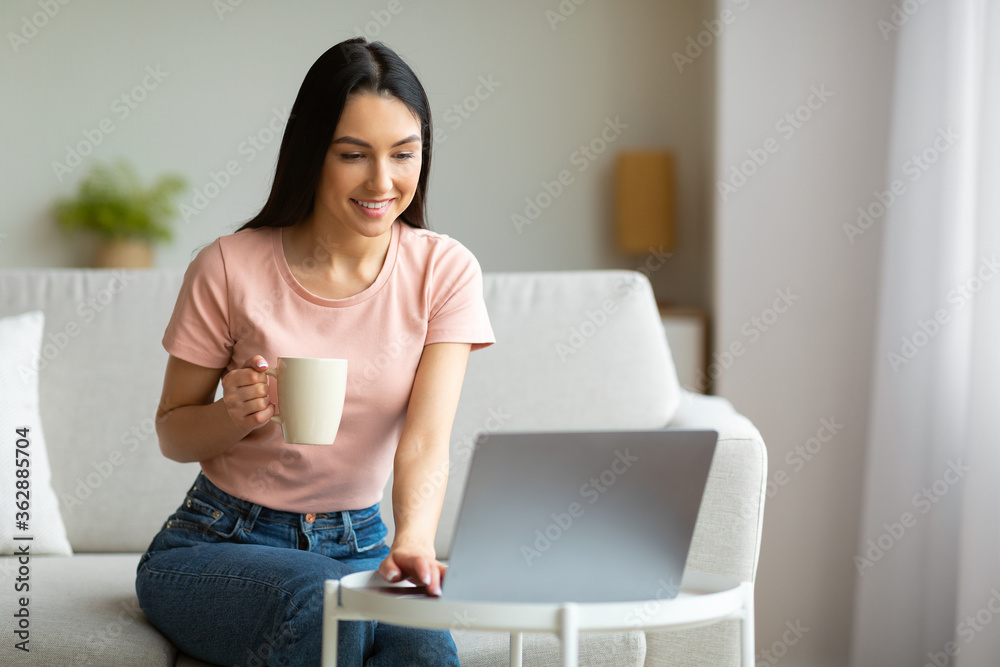 Cheerful Girl Watching Movie On Laptop Enjoying Coffee At Home