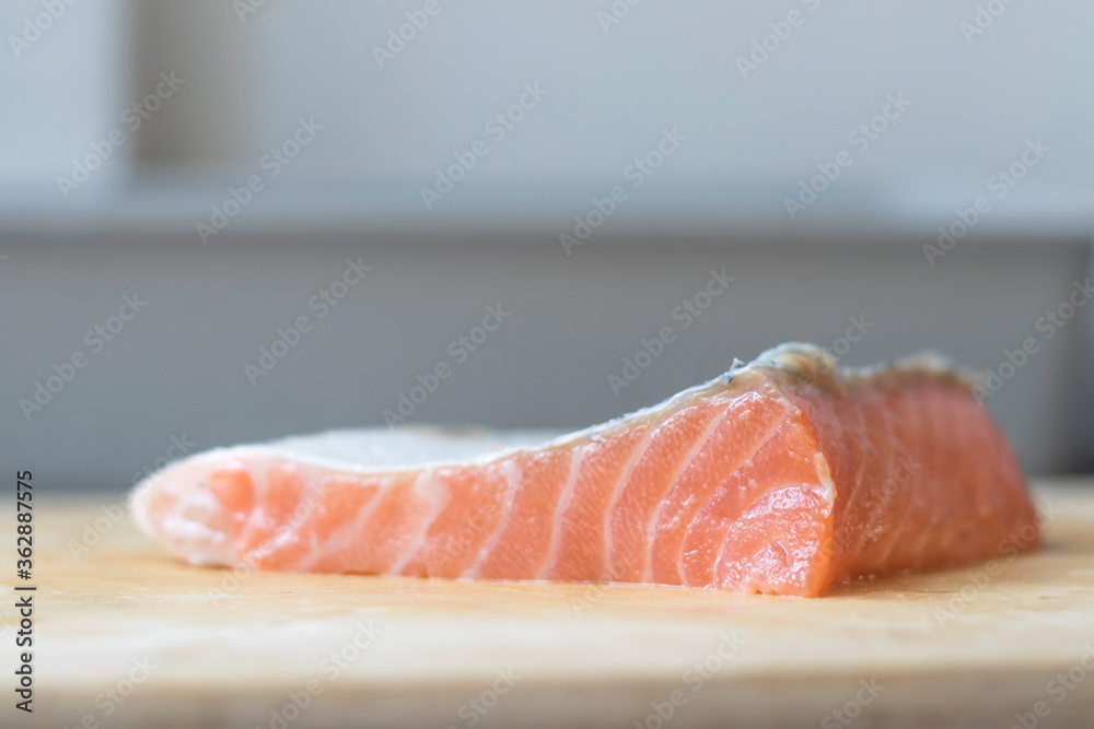 Salmon slices resting on a wooden chopping board. Salmon slices resting on a wooden chopping board.