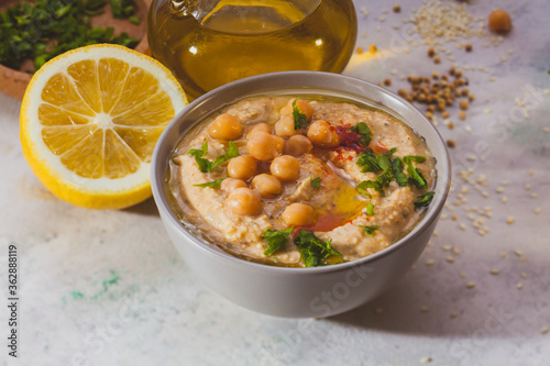 Bowl of hummus with chick peas and greenery on top