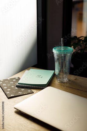 A workplace for creative person with notebook paper and mug with water