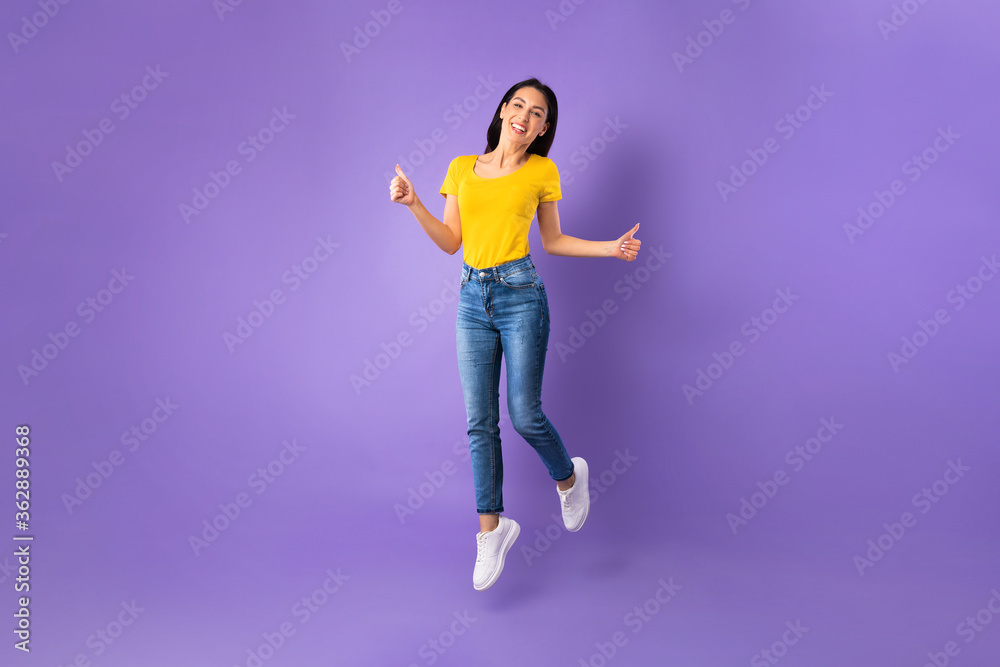 Happy woman jumping and looking at camera Happy woman jumping and looking at camera