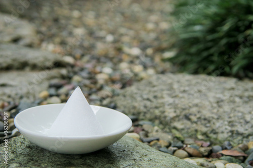 Photography Morijio (盛り塩) or Morishio (a pile of salt) on a small plate on the wet stone