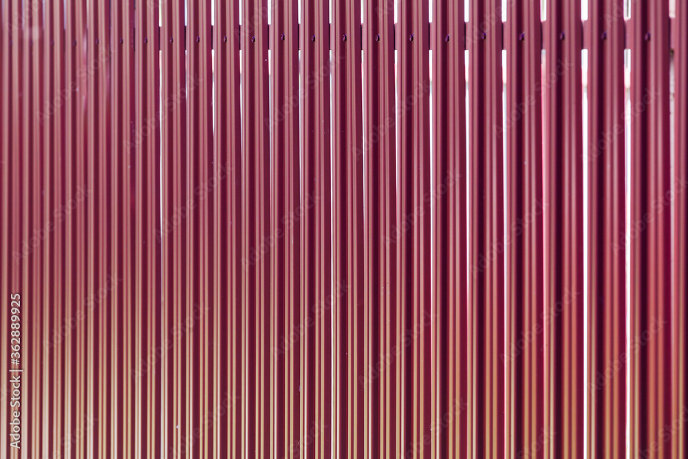 Outdoor fence made of red metal planks Outdoor fence made of red metal planks