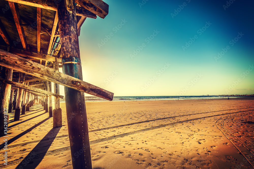 Wooden pier and golden sand in Newport Beach at sunset Wooden pier and golden sand in Newport Beach at sunset