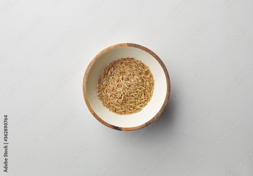 Top view shot of brown rice on white background.