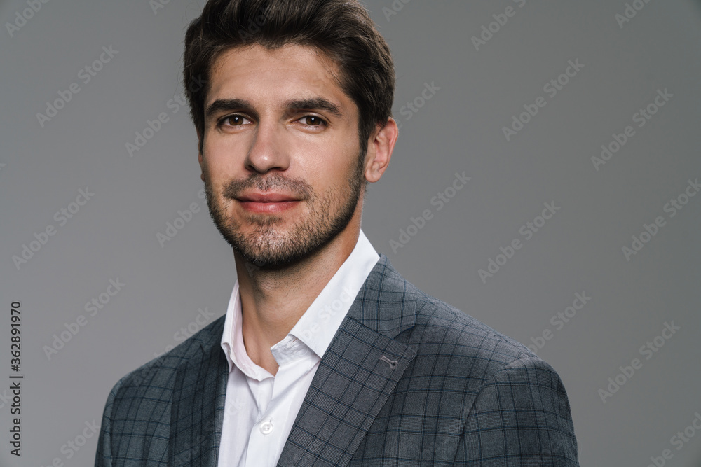 Photo of pleased businessman in jacket posing and smiling at camera Photo of pleased businessman in jacket posing and smiling at camera