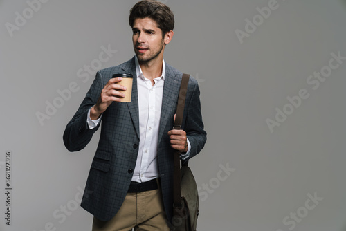 Obraz na plátne Photo of respectable confident businessman drinking coffee takeaway
