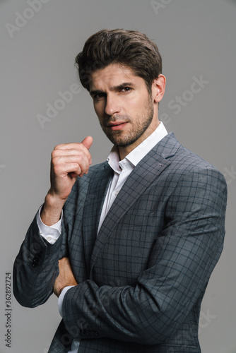 Photo of respectable confident businessman posing and looking at camera
