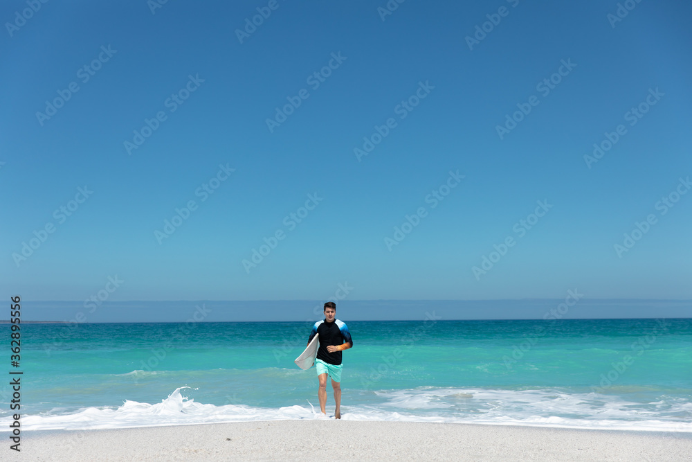 Young man with surfboard at the beach