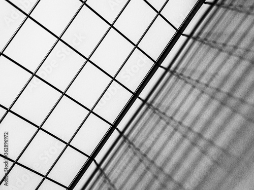 Black and white top view of a metal grid casting shadows