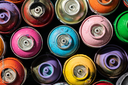 Top view of used spray paint cans with multiple colors