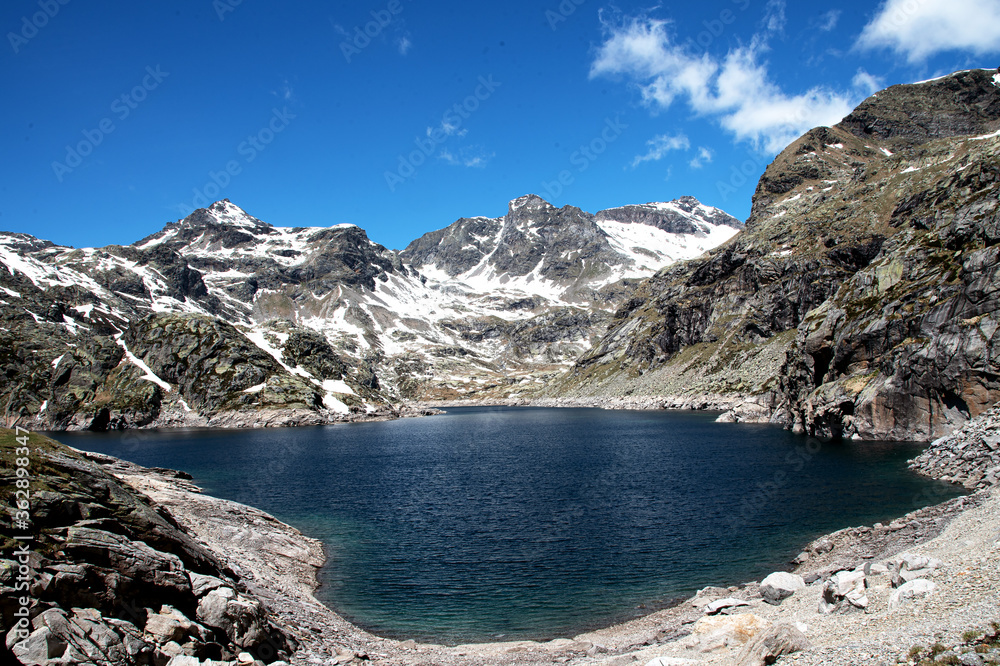 Mountain Lake Alps Italy, with snow peak in the background Mountain Lake Alps Italy, with snow peak in the background