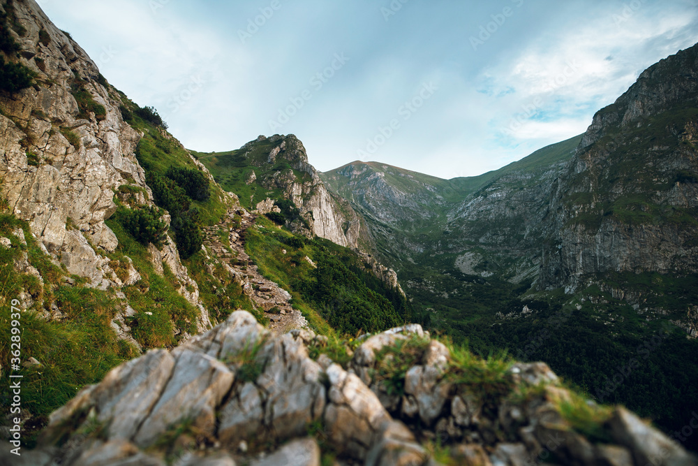 Scenic view of beautiful rocky mountains and cliffs with green grass and hills. Rysy mountains, High Tatry, Poland, Slovakia. 