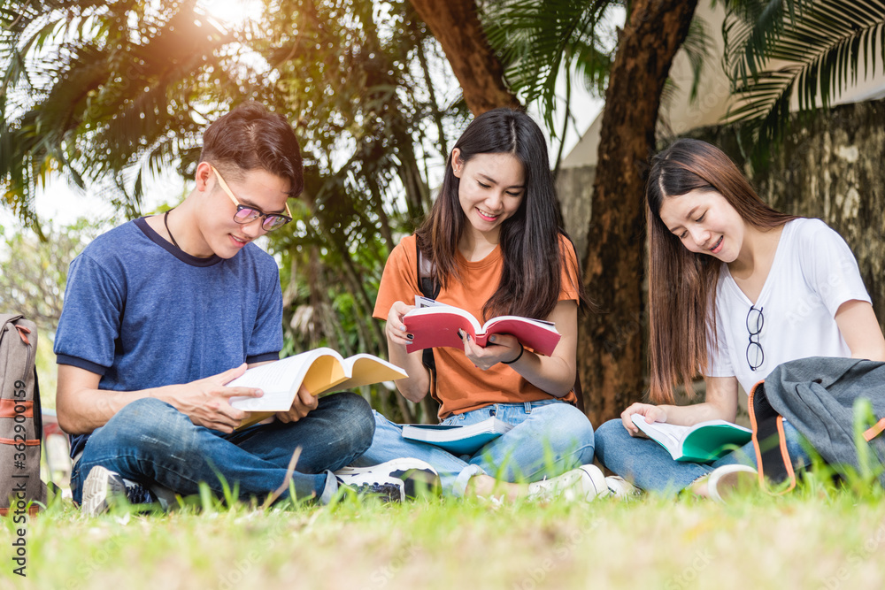 Happy young Asian young group of man and woman students are sitting during reading books in the park at university, Education concept, Education back to university concept Happy young Asian young group of man and woman students are sitting during reading books in the park at university, Education concept, Education back to university concept