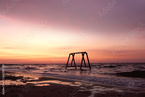 Swing in the sea on a deserted beach at dawn.