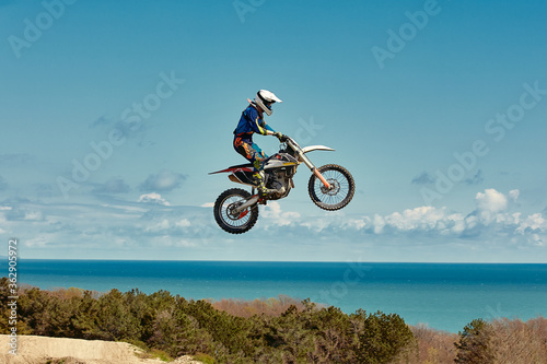 Fototapeta Naklejka Na Ścianę i Meble -  Extreme concept, challenge yourself. Extreme jump on a motorcycle on a background of blue sky with clouds. Copy space, all or nothing.