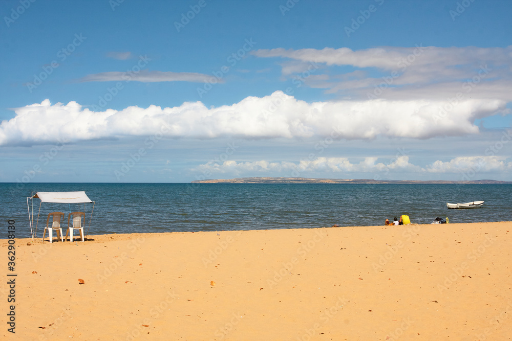 Sunny day on a beach with caribbean clouds.