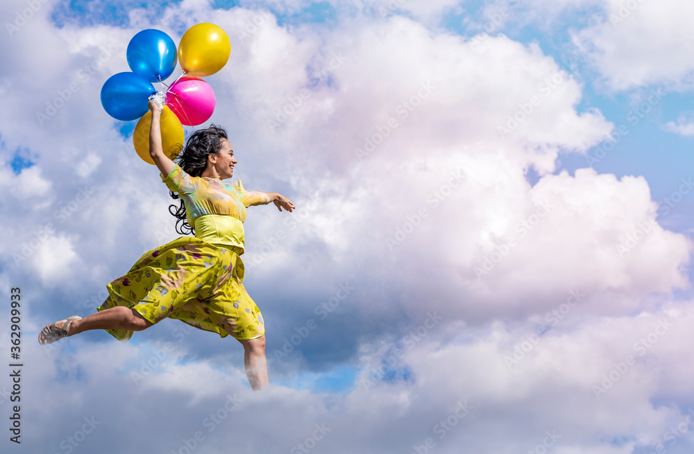 Young brunette girl in a green dress dancing flies on balloons high in the sky Young brunette girl in a green dress dancing flies on balloons high in the sky