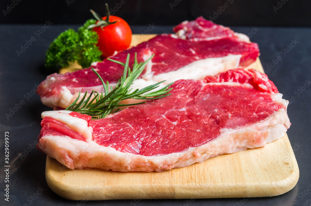 Fresh rare  striploin beef portion on  wood bord