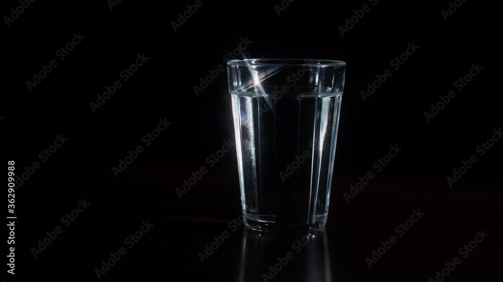 Shiny empty glass of water rolling on a dark background Shiny empty glass of water rolling on a dark background