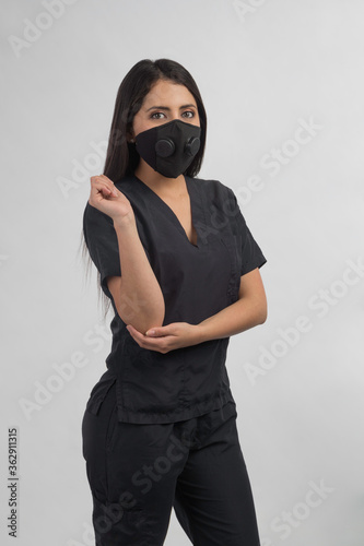 nurse dressed in black with mask, studio with gray background