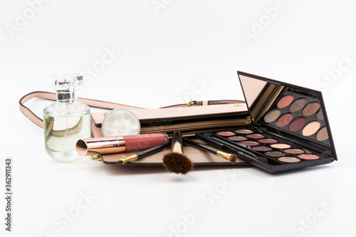 Cosmetics, perfume, brushes, patelle with eye shadows. female cosmetics bag on white background. Make up. Copy space. Set of woman's cosmetics in a bag. Women's secrets.