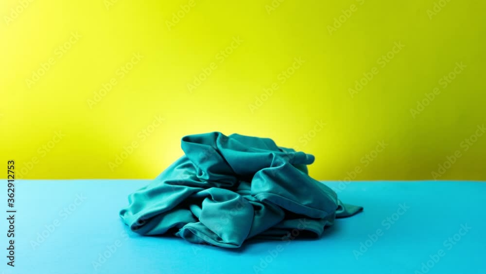 Stop motion animation of pile clothes on blue table Seamless loop video Time Lapse